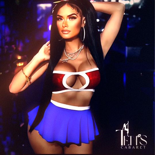 A performer in a red-and-white top and a blue pleated skirt stands with both arms raised against a dark violet ground, the Ten’s Cabaret wordmark set into the lower right of the frame.